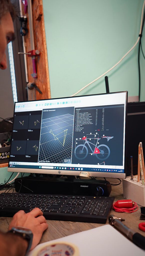 Computer screen showing the STT Systems 3DMA analysis software. A bicycle model and biomechanics data are visible for optimizing the cyclist's performance.